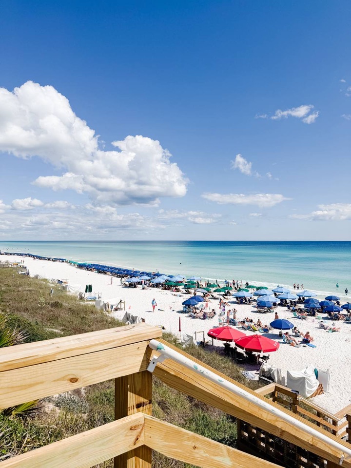 White-sand beach and turquoise water seen from a wooden walkover
